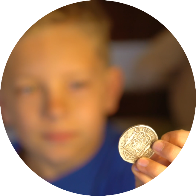 Young boy looking at coin